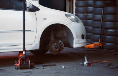 The white color Car for repair in shed without wheel in Peoria, AZ