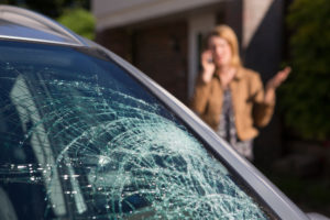 woman on call behind cracked car glass car