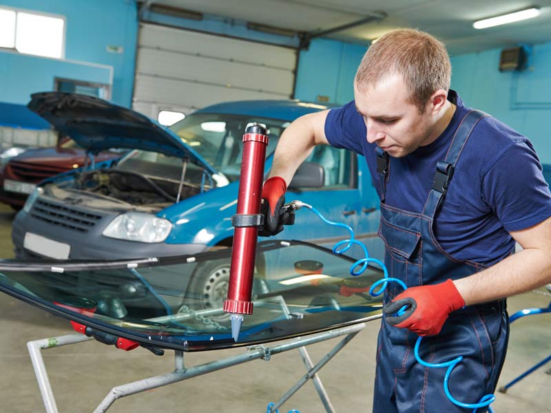 The man putting glue on the windshield for pasting at Las Vegas, NV Auto Glass Exp[ert Repairing Windshield in Las Vegas, NV