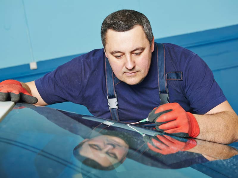 The auto glass express staff repairing the car wind shield 