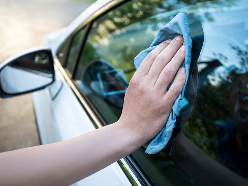 a man wiping a car window