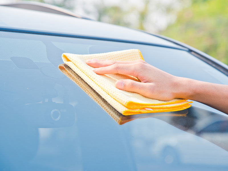 car front window cleaned with duster