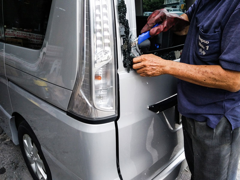 man fixing a car window