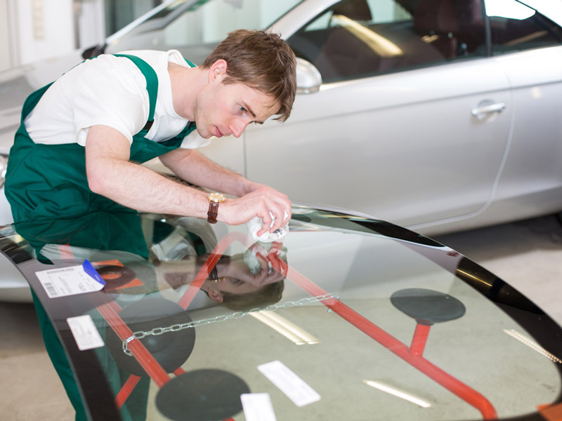 a man cleaning a windsheild