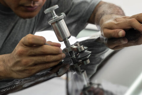 a man repairing a crack in a windsheild