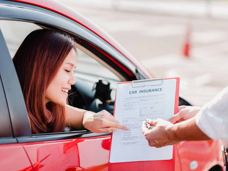 woman signing car insurance