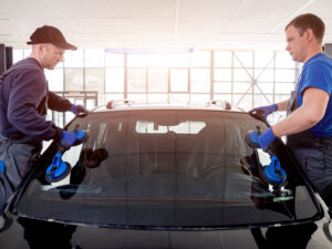 two men replacing windshield